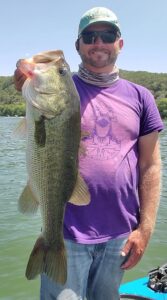 Angler holding a largemouth bass caught on Lake Austin in August 2025 during a guided trip with Bassquatch Fishing.
