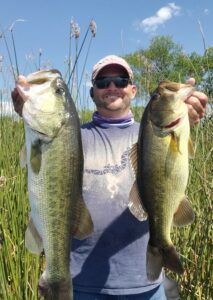 Angler holding two largemouth bass from Inks Lake, September 2025.
