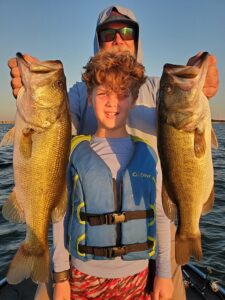Father and son holding quality largemouth bass caught at Stillhouse Hollow Lake during a guided trip in October 2025. Fish were caught on weightless soft plastic jerkbaits and mid-strolling minnow-style baits on a sunny afternoon.