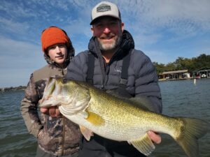 Client holding a largemouth bass caught on Lake LBJ in January 2026 on a finesse jig near a hard-bottom dock.