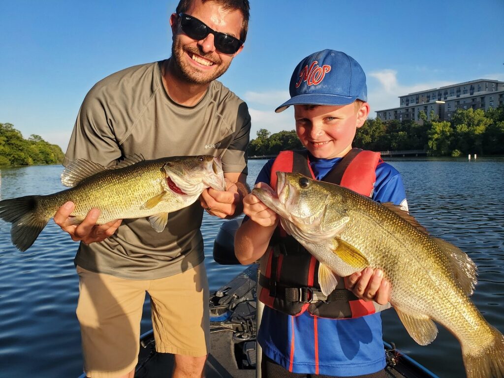 Uncle and nephew holding largemouth bass caught during a Lady Bird Lake guided fishing trip using Neko-rigged creature baits.
