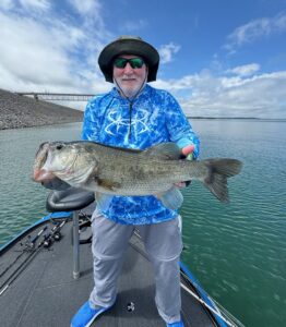 Client holding a large largemouth bass caught on Stillhouse Hollow Reservoir using a drop-shot rigged finesse worm around submerged vegetation.
