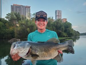 Client holding a giant largemouth bass caught on Lady Bird Lake during a guided fishing trip in Austin, Texas