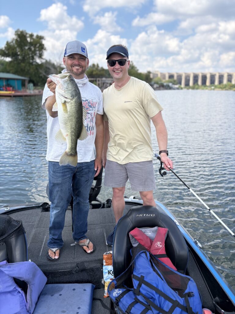 Two longtime friends fishing together on Inks Lake with a quality largemouth bass